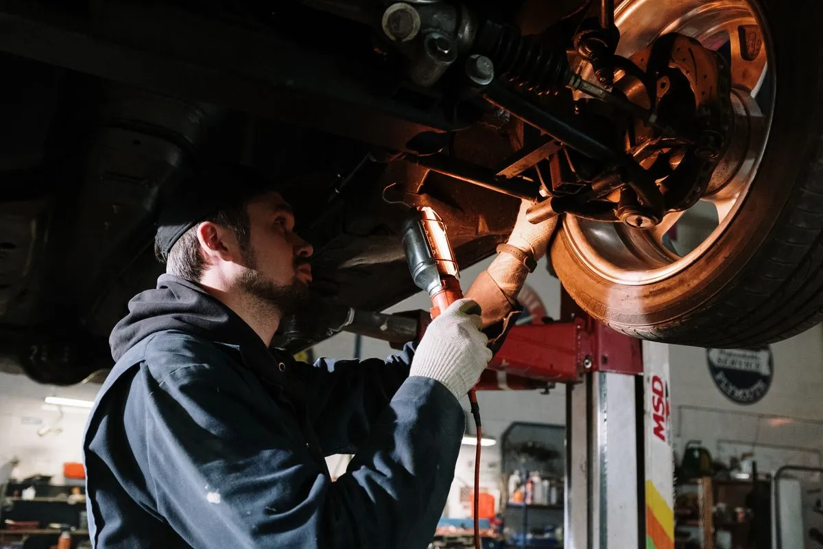 Mechanic working underneath a car for a Fillongley customer